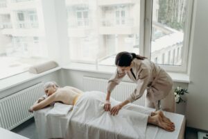 Senior woman enjoying a therapeutic massage in a peaceful indoor spa setting.